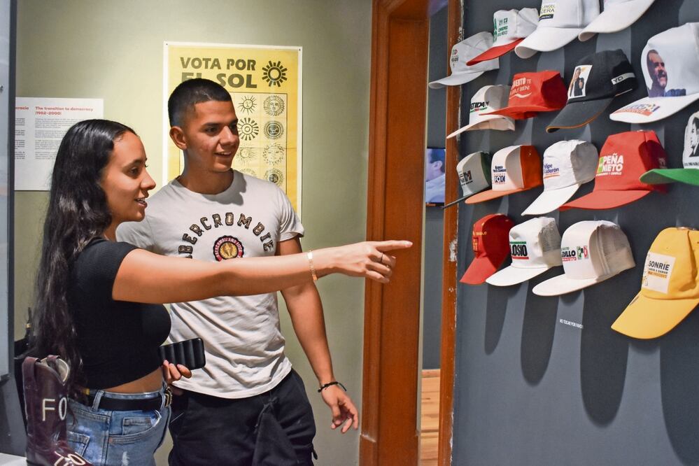 Asistentes al MODO observan las clásicas gorras con el nombre y rostro de los candidatos, que son objetos que no pasan de moda en cada proceso electoral en el país. Foto: Eduardo Castañeda | El Universal