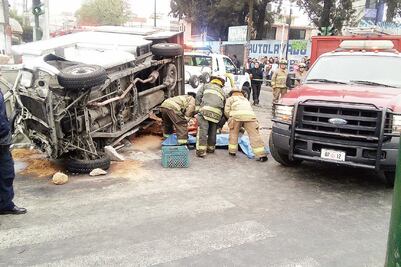 Camión vuelca y prensa a joven