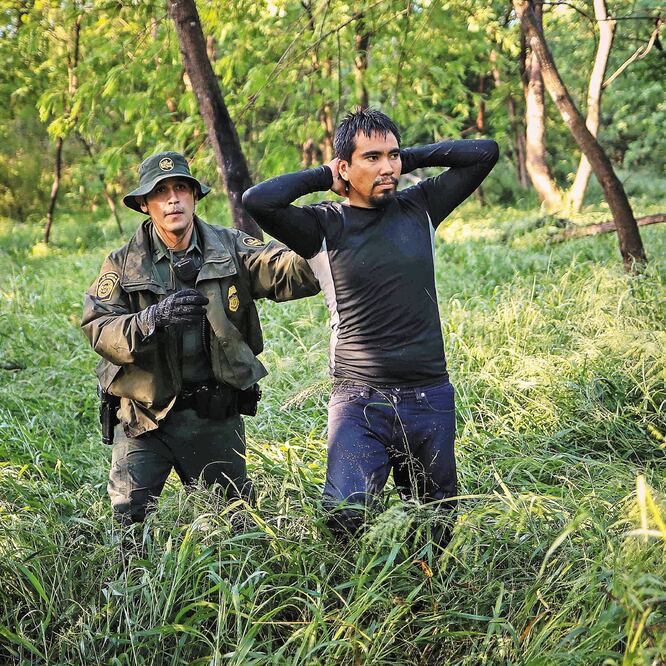 Un agente de la Patrulla Fronteriza detiene a un hondureño que entró ilegalmente a Estados Unidos en el límite con México, en Misión, Texas. (ADREES LATIF. REUTERS)