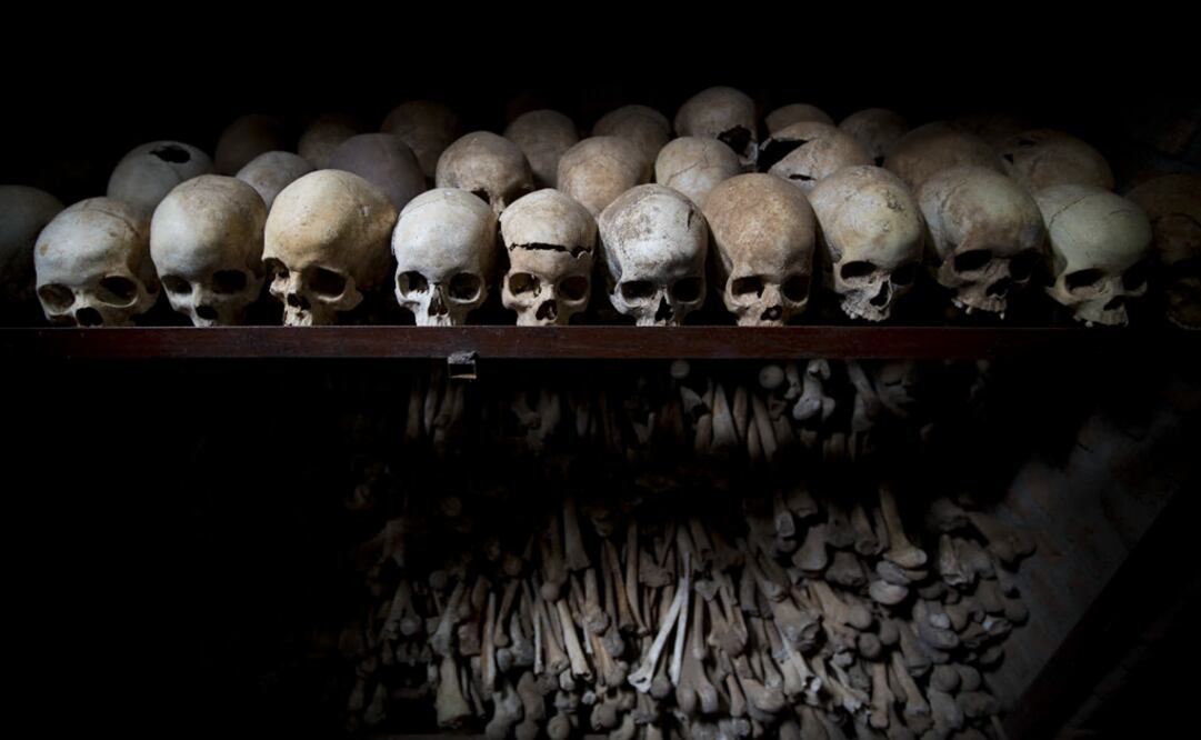 The skulls and bones of some of those who were slaughtered as they sought refuge inside a church, are laid out on shelves in an underground vault as a memorial - Photo: Ben Curtis/AP