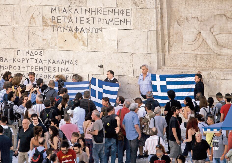 Manifestantes portan banderas griegas, afuera del Parlamento en Atenas. Foto: YANNIS BEHRAKIS. REUTERS