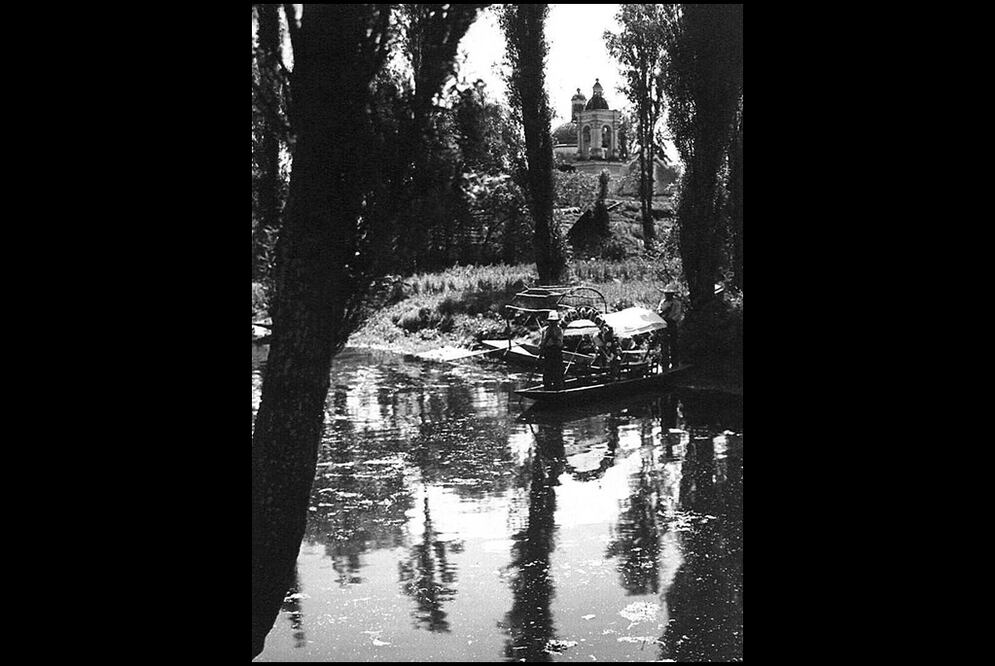 Vista de uno de los canales de Xochimilco hacia la década de los cuarenta. En el fondo destaca la capilla de la Santísima Trinidad Chililico, ubicada en el barrio del mismo nombre; este templo fue concluido en 1897 y restaurado a mediados del siglo XX. 
