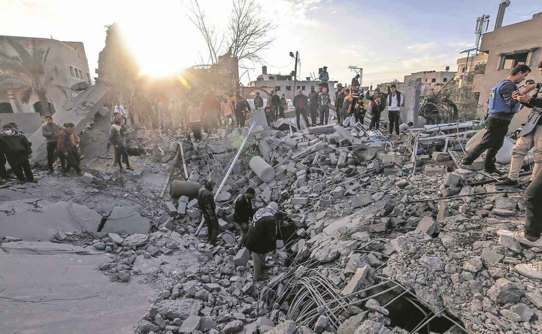 Los palestinos inspeccionan los escombros de una mezquita y edificios, tras el bombardeo alrededor de Rafah. Foto: AFP