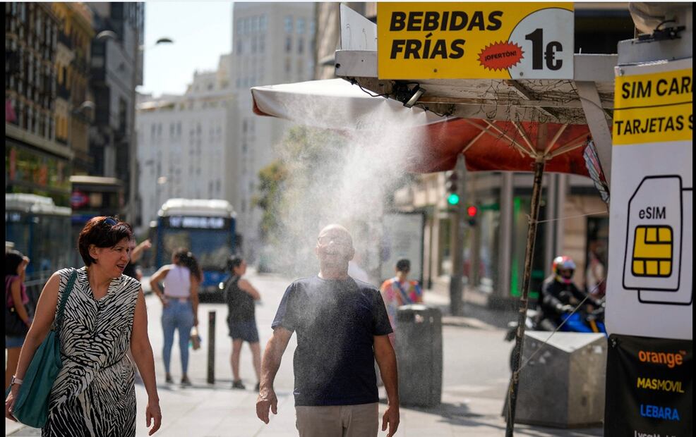 Un hombre se refresca al pasar bajo un nebulizador de agua frente a un quiosco en Madrid, España, el 5 de agosto de 2025. Las temperaturas se dispararon durante la segunda ola de calor en la Península Ibérica con temperaturas de hasta los 43 grados, según informó la Agencia Estatal de Meteorología. Foto: AFP