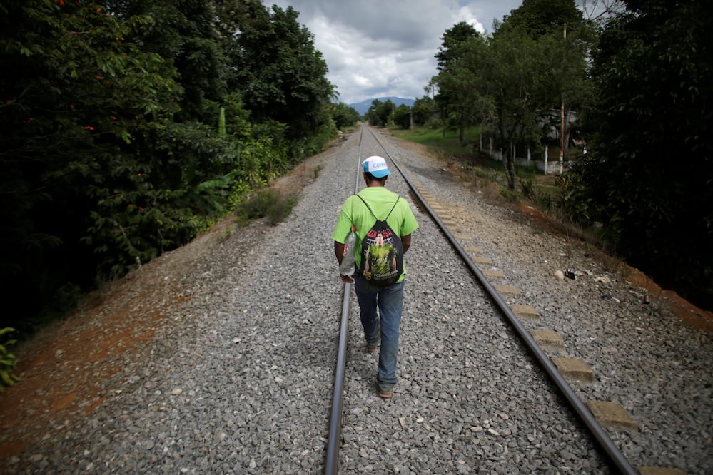 An immigrant walks along a railroad - Photo: Daniel Becerril/REUTERS