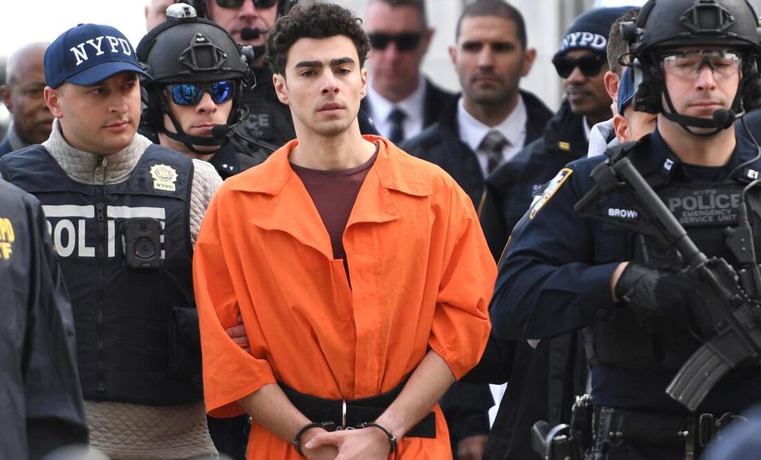 Luigi Mangione, sospechoso del asesinato a tiros del director ejecutivo de UnitedHealthcare, Brian Thompson, es escoltado por la policía. Foto: AP