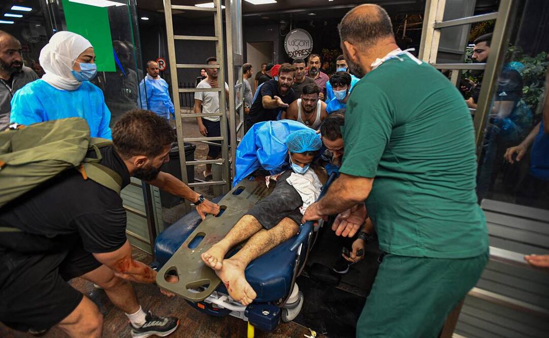 Personal médico recibiendo a una persona herida luego de un ataque militar israelí contra un edificio en el suburbio del sur de Beirut. Foto: AFP