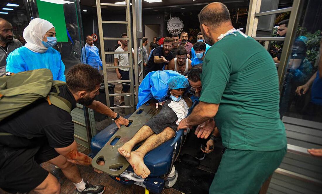 Personal médico recibiendo a una persona herida luego de un ataque militar israelí contra un edificio en el suburbio del sur de Beirut. Foto: AFP