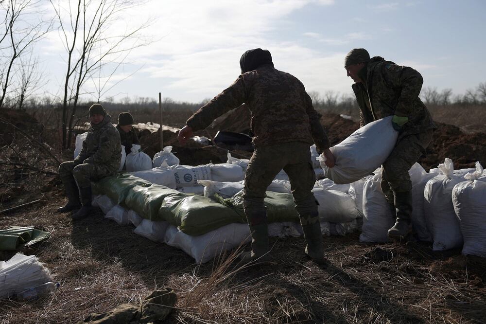 Los militares ucranianos amontonan sacos de tierra para construir una fortificación no lejos de la ciudad de Avdiivka, en la región de Donetsk, en medio de la invasión rusa de Ucrania, el 17 de febrero de 2024. Foto: AFP