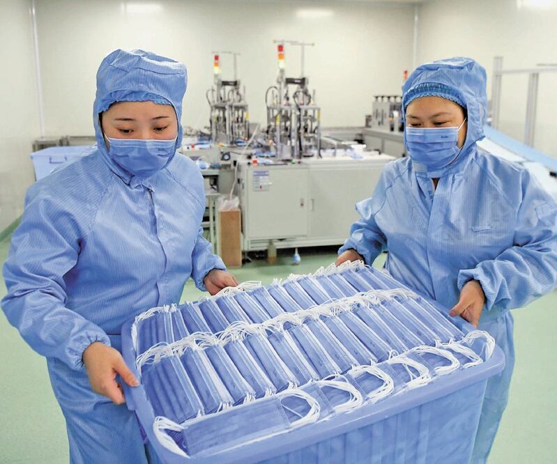 Unas empleadas de un taller de producción de tapabocas en una compañía de dispositivos médicos en el distrito Nan’an de Chongqing, suroeste de China. WANG QUANCHAO. REUTERS