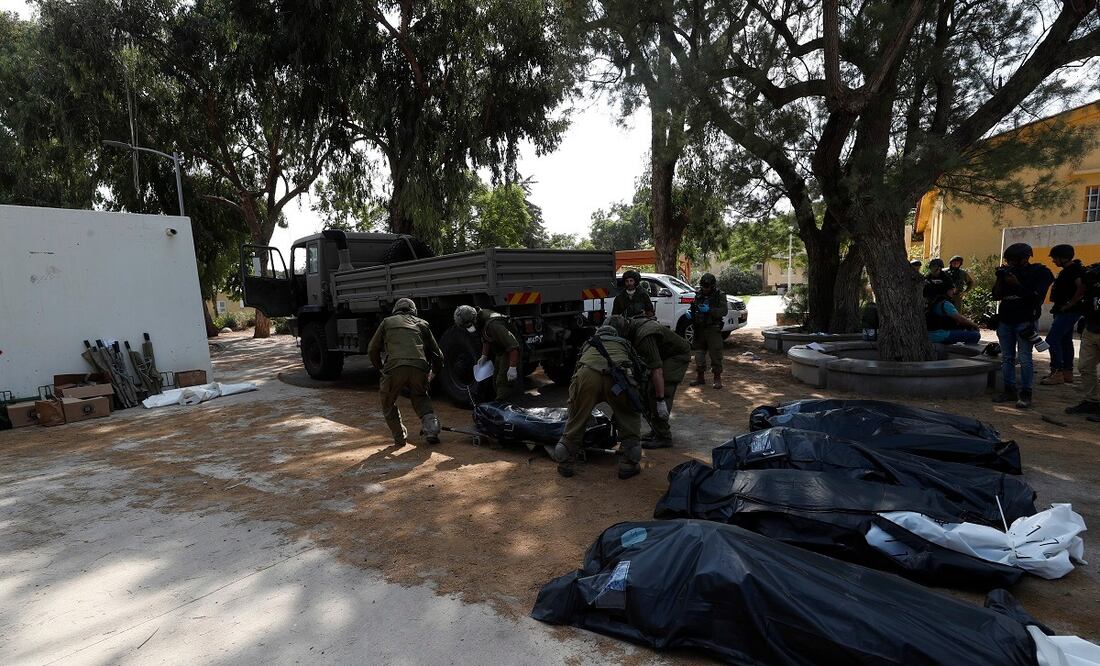 Soldados israelíes se llevan los cuerpos de los israelíes muertos en el kibbutz de Kfar Aza, cerca de la frontera con Gaza, tras la incursión del grupo islamista Hamas. Foto: EFE