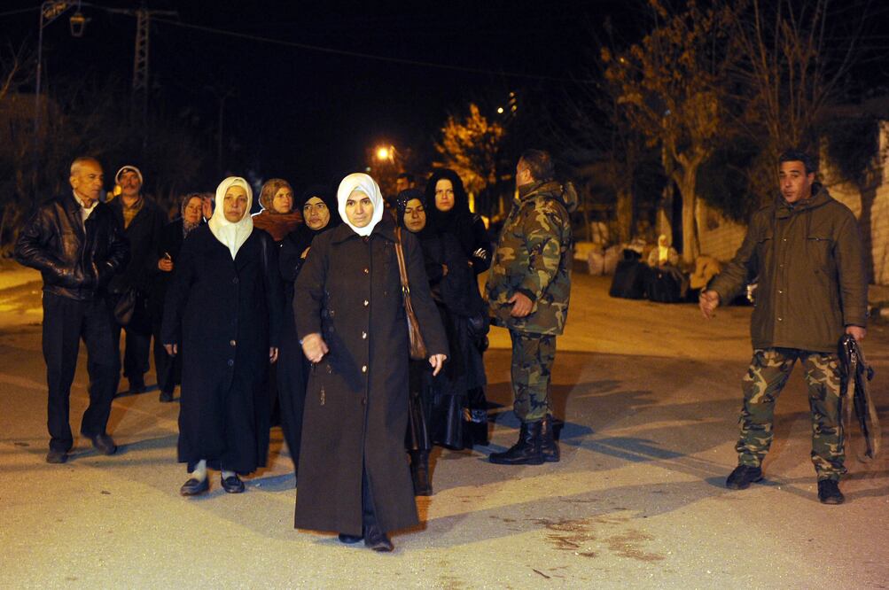 Personas se reúnen en una calle en la aldea de Madaya, con ayuda como parte de un acuerdo recién logrado entre el gobierno y los rebeldes para mitigar el sufrimiento de personas con hambre (XINHUA)