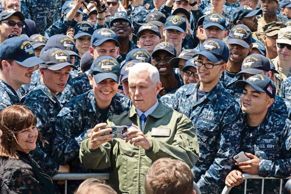 El vicepresidente de EU, Mike Pence, posa para una selfie con miembros de la tripulación de portaaviones USS Ronald Reagan, en Japón (AFP)