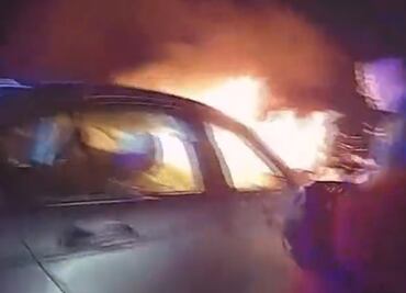 De entre las llamas de su auto, policías rescatan a hombre por las ventanas del vehículo