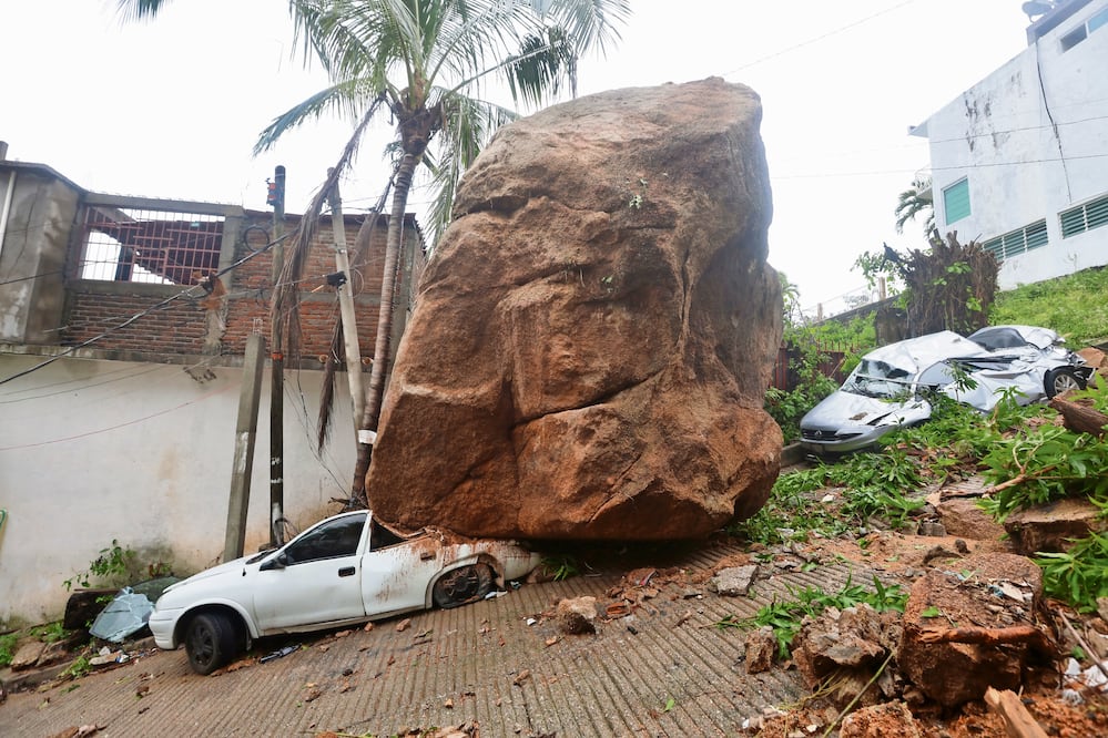En la colonia Icacos una enorme roca se desprendió y aplastó dos vehículos, y aún no ha sido retirada. Foto: de Valente Rosas. El Universal