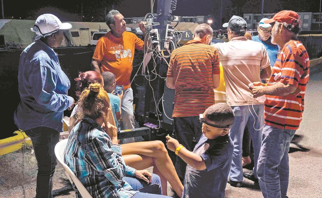 Personas cargan sus celulares en una torre de luz portátil, en Guanica. Foto: RICARDO ARDUENGO. AFP