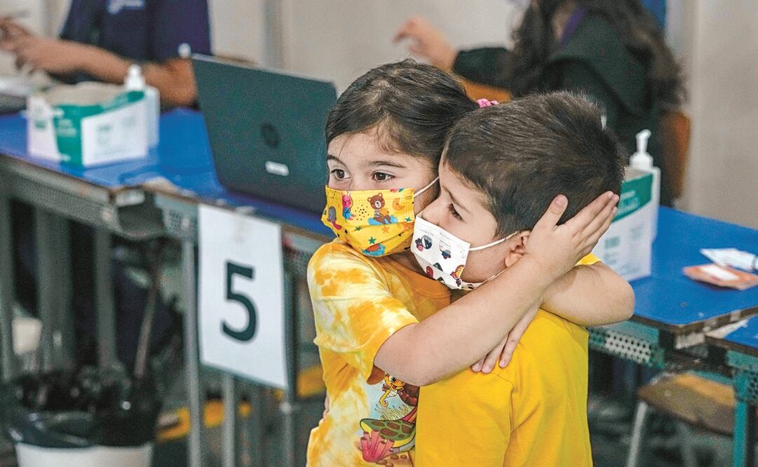 Emilia Gutiérrez, de seis años, consuela a su hermano Vicente, quien ayer recibió la primera dosis de Sinovac en un centro de vacunación en Santiago de Chile. Foto: Esteban Felix. AP
