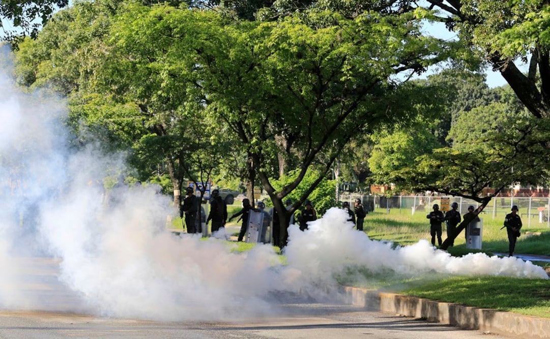 Agentes de la Guardia Nacional Bolivariana lanzan gas lacrimógeno a residentes que intentan llegar al fuerte militar Paramacay de la ciudad de Valencia, Venezuela (Foto: AP)