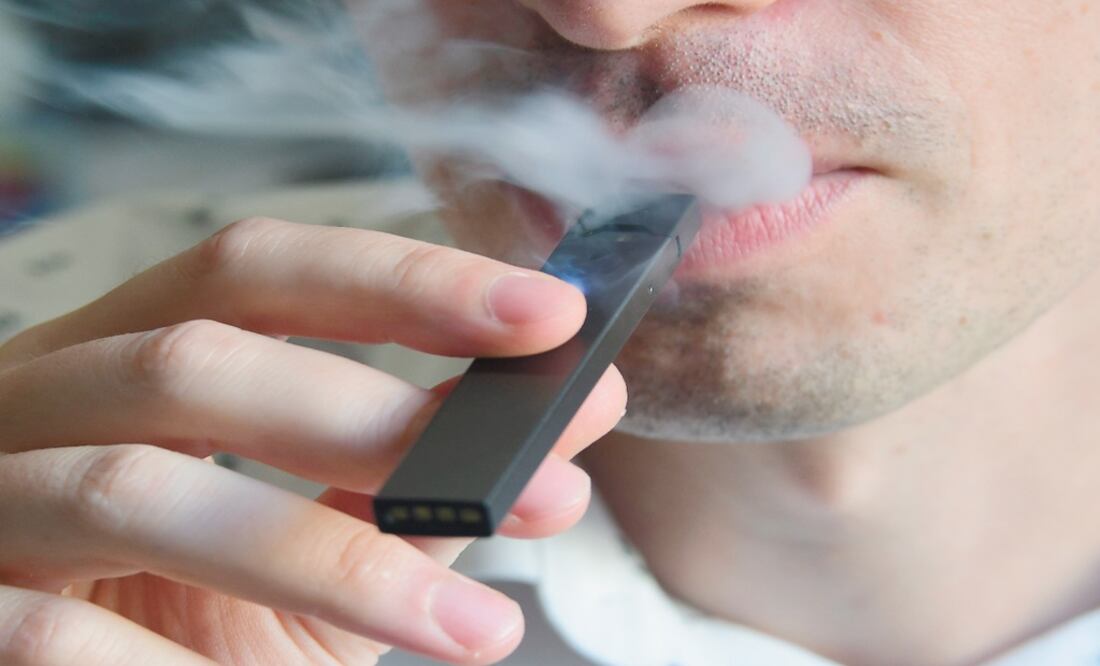 A man exhaling smoke from an electronic cigarette - Photo: Eva Hambach/AFP