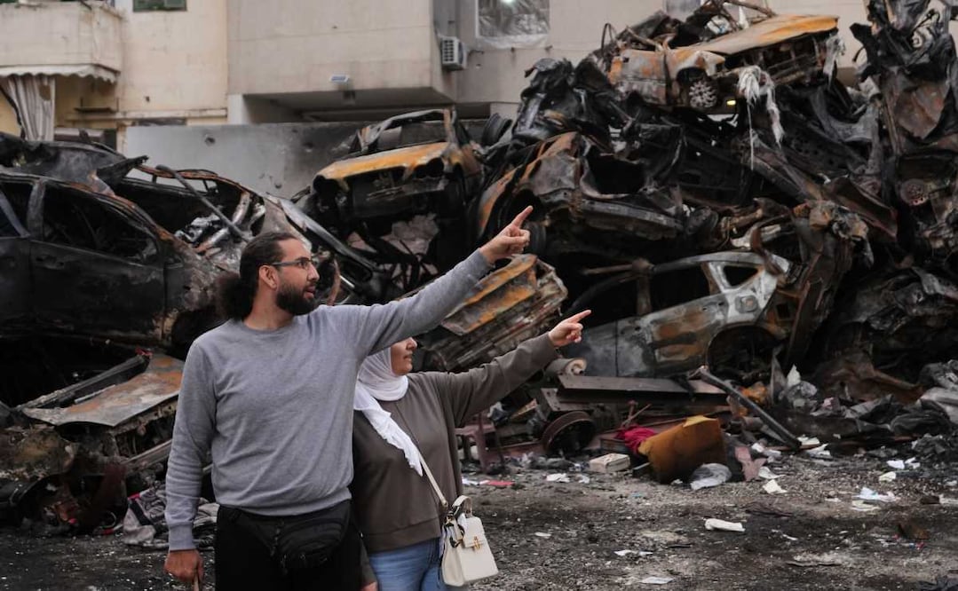 Residentes señalan hacia los daños parados delante de autos calcinados en un edificio destruido por un ataque aéreo israelí en el centro de Beirut, Líbano, el 14 de abril de 2026. Foto: AP