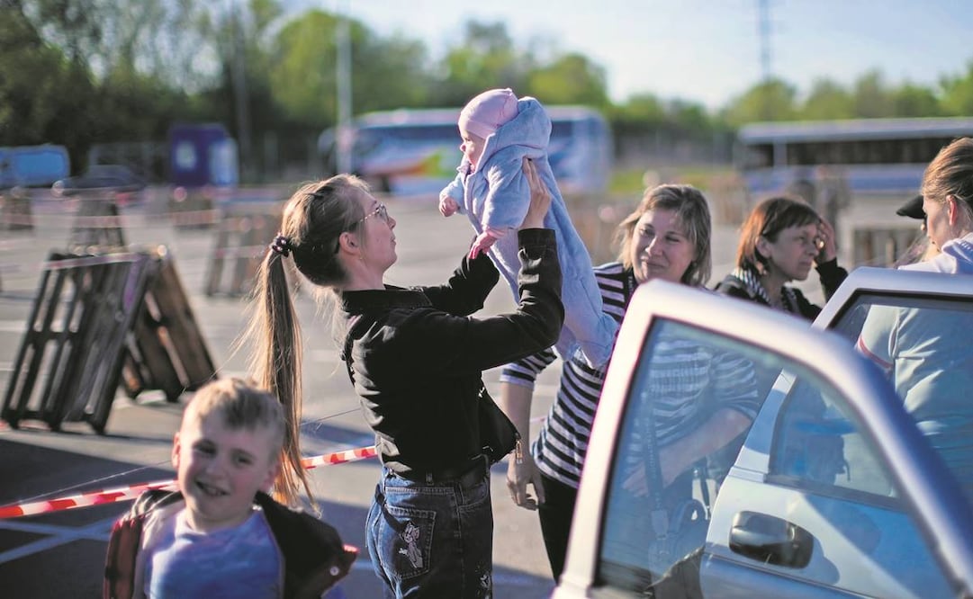 Una ucraniana sostiene a un bebé, mientras una familia que huyó de Enerhodar se reúne a su llegada a un centro de recepción para los desplazados en Zaporizhia. Foto: Francisco Seco/AP