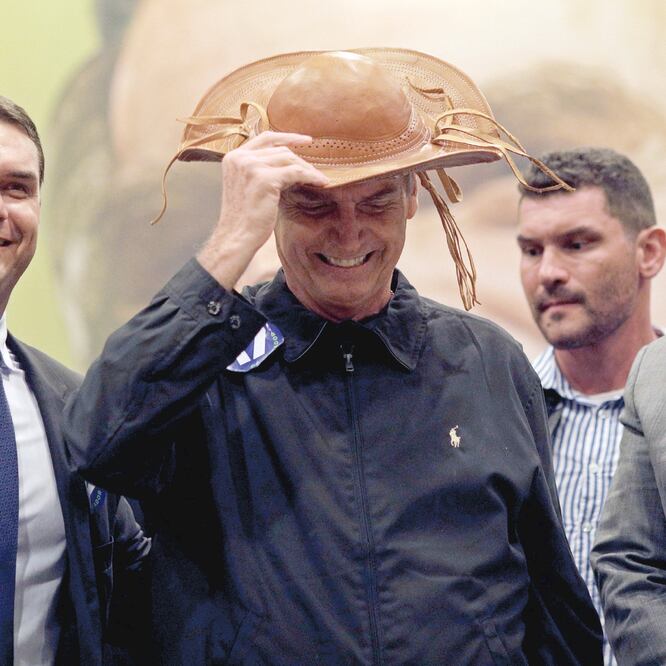El candidato presidencial Jair Bolsonaro (centro), acompañado de su hijo Flavio (izq.), al llegar a una conferencia de prensa ayer en Río de Janeiro. Foto: RICARDO MORAES. REUTERS