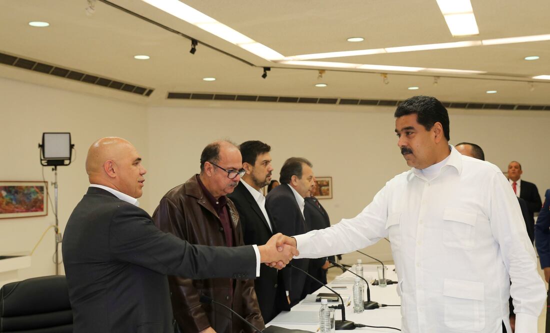 El presidente venezolano Nicolás Maduro estrecha la mano con el secretario de la Mesa de la Unidad Democrática (MUD), Jesús Torrealba, durante una mesa exploratoria para un diálogo entre el gobierno y la oposición (Foto: Xinhua)