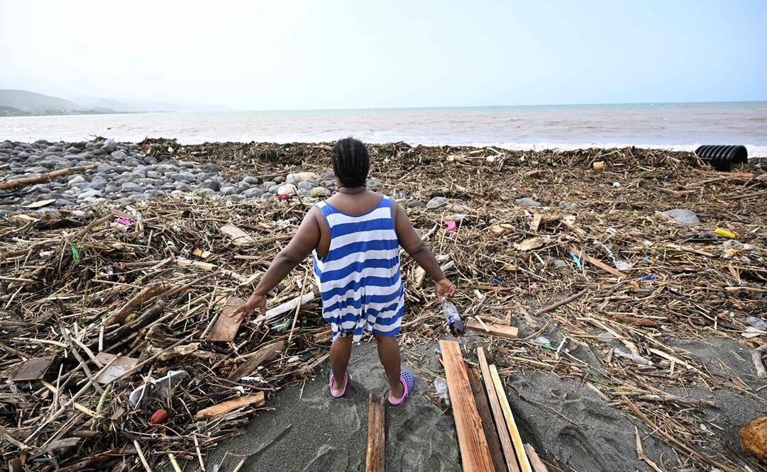 Una mujer mira una playa llena de basura en Bull Bay, Jamaica, tras el paso del huracán Beryl. AFP