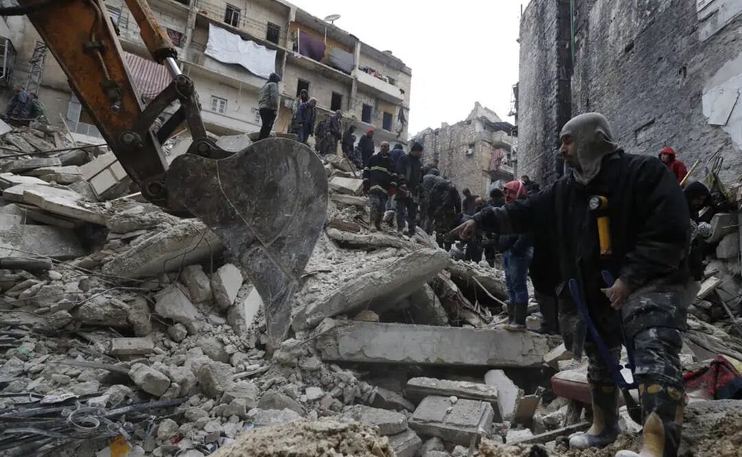 Trabajadores de protección civil y fuerzas de seguridad de Siria buscan entre los escombros de un edificio que se desplomó. Foto: AP