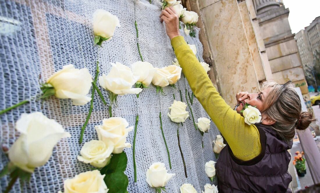 Una colombiana coloca rosas de la paz en un edificio del gobierno (IVÁN VALENCIA. AP)