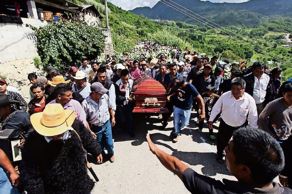 Un grupo de hombres cargaba el féretro del alcalde Domingo López hacia el cementerio del poblado. Mientras un mariachi y una banda acompañaban el trayecto, pobladores observaban la procesión desde los techos (FREDY MARTÍN PÉREZ. EL UNIVERSAL)