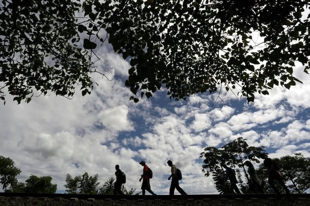 Immigrants walk toward the premises of a group called ''The bosses," a charitable organization that feeds Central American immigrants on their way to the border with the U.S. who travel atop a freight train known as ''La Bestia''. REUTERS/Daniel Becerril