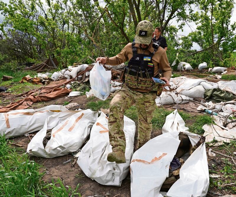 Un militar ucraniano, durante la exhumación de los soldados rusos muertos a las afueras de Kharkiv. Foto: Andrii Marienko/AP