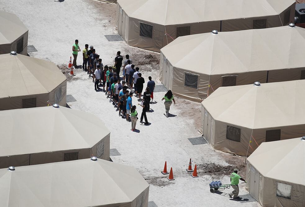 Niños migrantes y trabajadores de ICE son vistos en un campamento de tiendas de campaña construido recientemente cerca del Puerto de Entrada de Tornillo, Texas. (Foto: AFP)