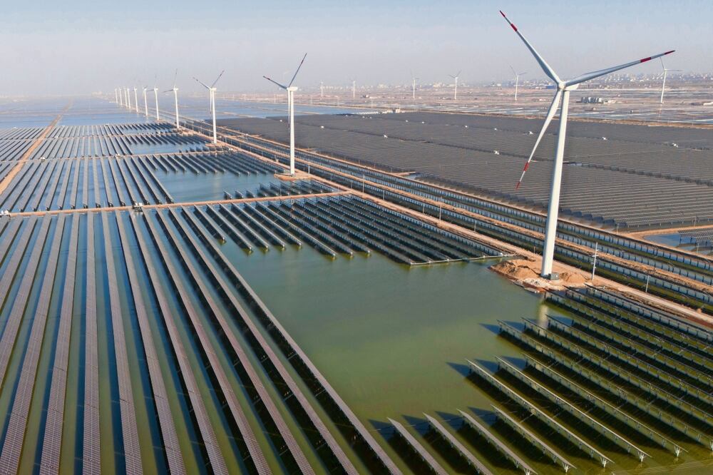 Turbinas eólicas en planta solar cerca de Weifang. China “podría estar en camino de lograr objetivos”, dice el reporte. Foto: Andre Penner / AP
