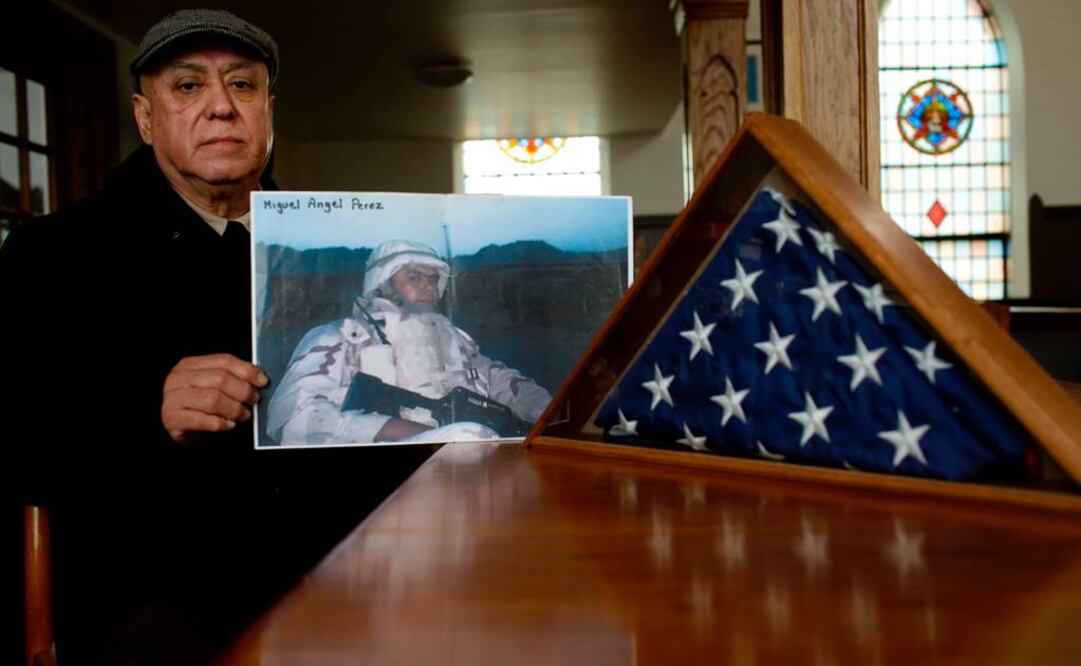 En la fotografía se observa a Miguel Perez sosteniendo la fotografía de su hijo. Archivo / AFP