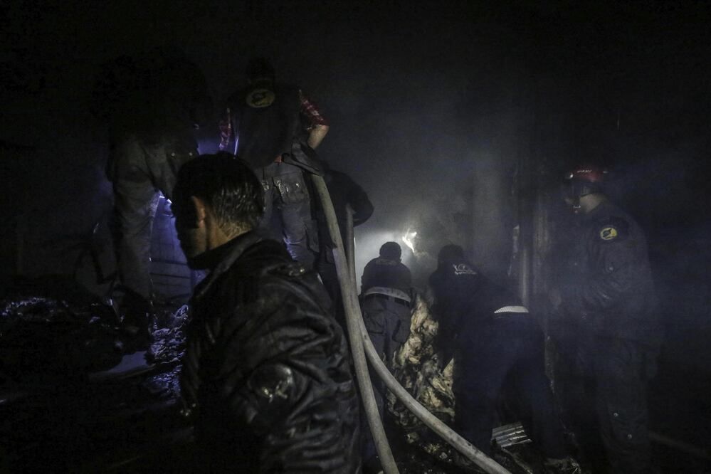 Voluntarios tratan de extinguir un incendio como consecuencia de los ataques aéreos y de artillería perpetrados contra distintas zonas de la región de Guta Oriental. (EFE)