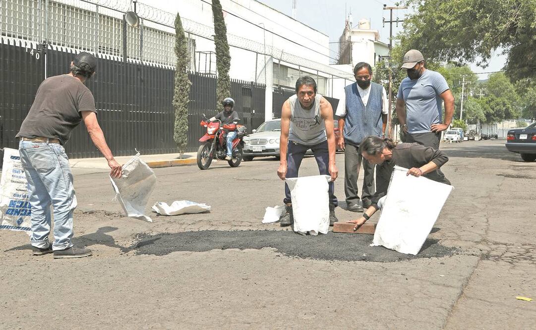 Los vecinos de la colonia Granjas México se organizaron y con sus recursos taparon al menos 30 baches. Foto: Carlos Mejía. EL UNIVERSAL