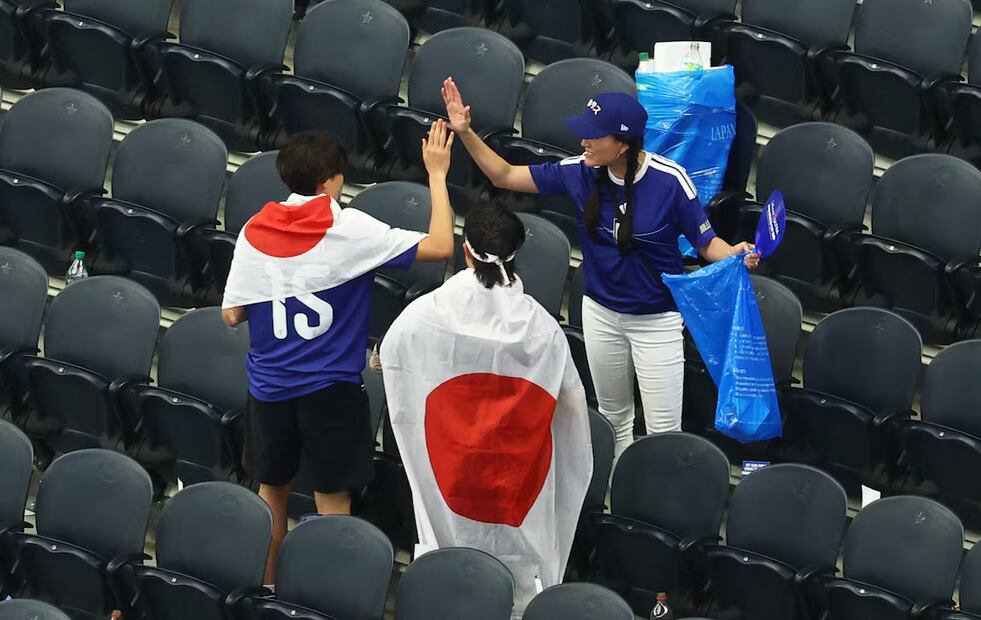 Japoneses recogiendo basura en el Estadio Dallas tras el partido de Japón vs Países Bajos. Foto: Reuters