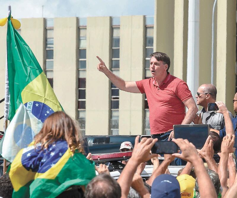 El mandatario brasileño, Jair Bolsonaro, con sus seguidores en una protesta contra las medidas de confinamiento, en Brasilia, el domingo. Foto: SERGIO LIMA. AFP