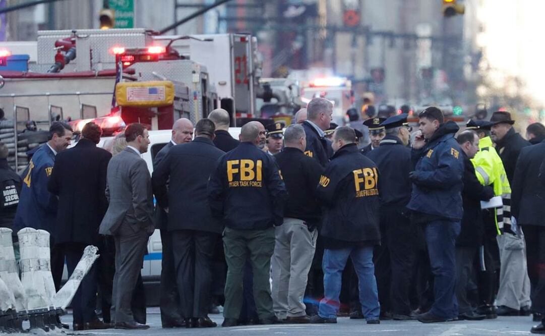 Agentes de la policía de Nueva York y agentes del FBI realizan su trabajo junto a la terminal de autobuses de la Autoridad del Puerto en Nueva York. EFE/JASON SZENES