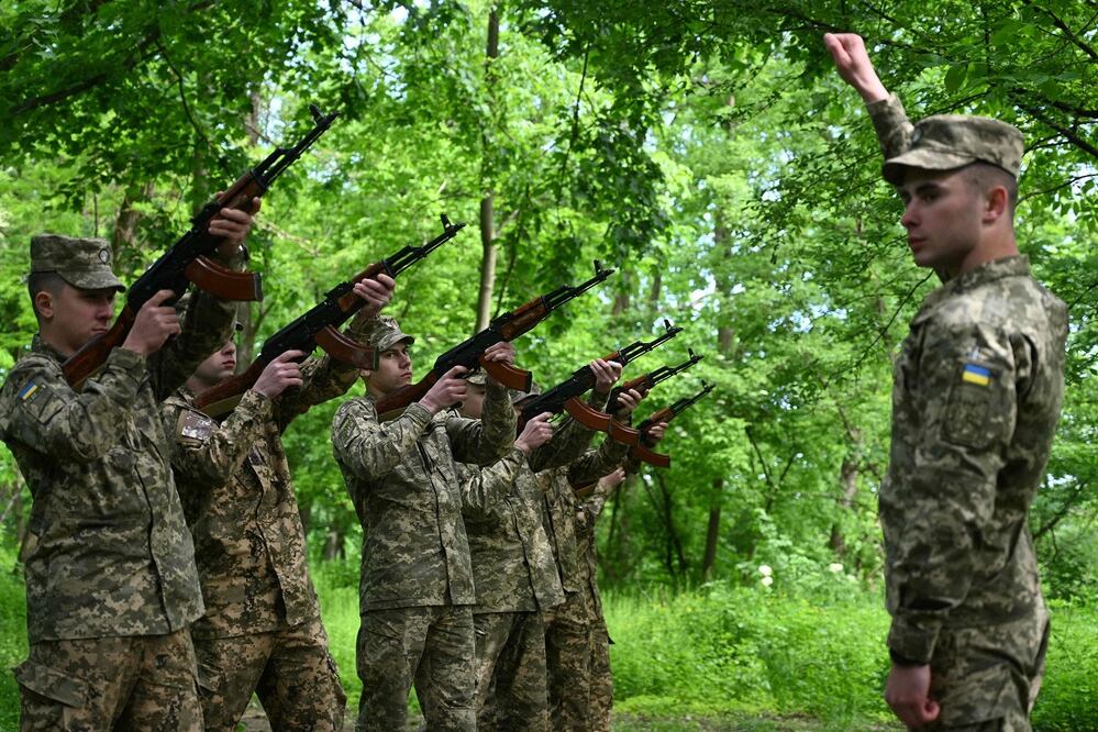 Soldados ucranianos se preparan para disparar sus rigles, durante una ceremonia por el Día de la Remembranza. FOTO: YURIY DYACHYSHYN. AFP