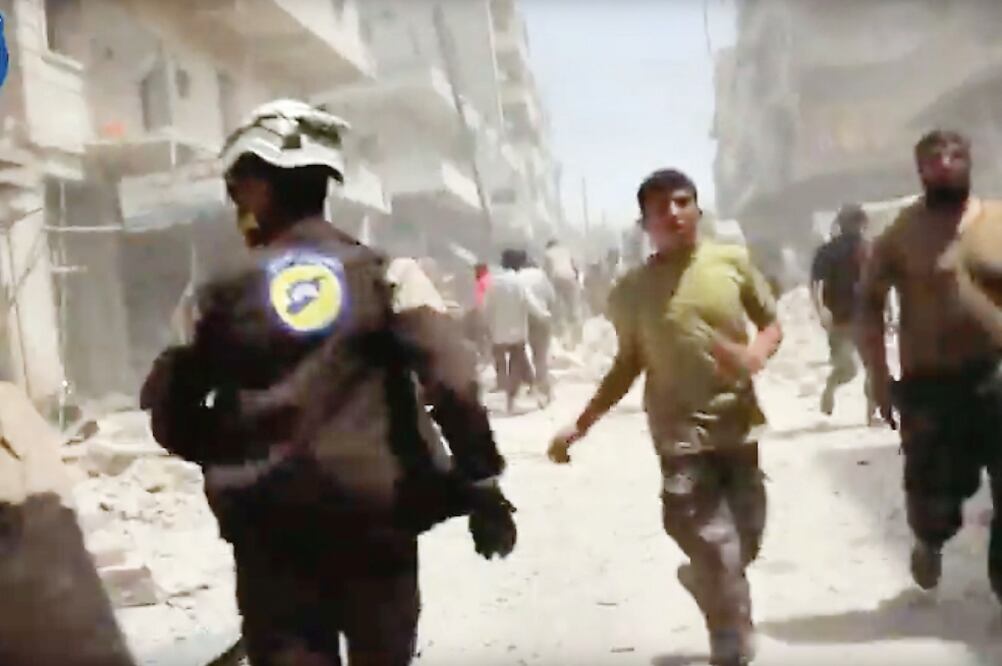 Captura de un video que muestra a sirios correr por el impacto de un bombardeo en Aleppo, ayer (AP)