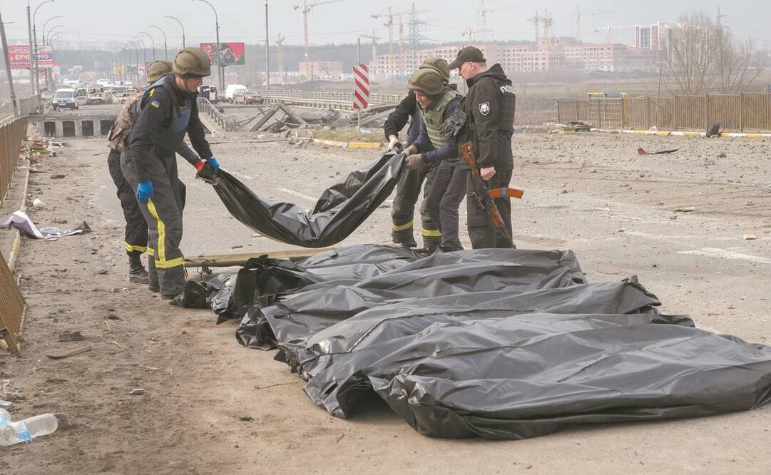 Soldados ucranianos, con los cuerpos de civiles asesinados por las fuerzas rusas en el puente destruido en Irpin, cerca de Kiev. Foto: Efrem Lukatsky/AP