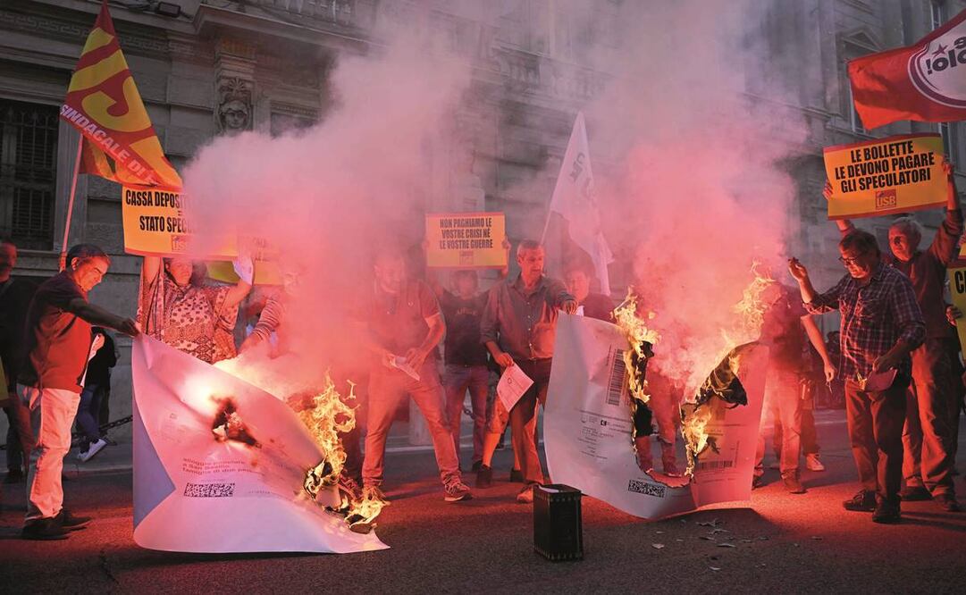 Manifestantes queman sus recibos de luz, durante una protesta organizada en Roma por un sindicato italiano ante el alto costo de la vida. Foto: Alberto Pizzoli/ AFP.