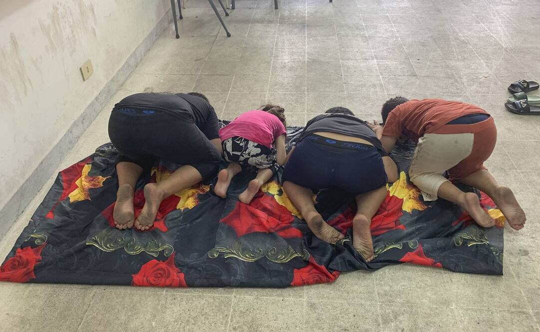 Cuatro niños rezan en el aula de un colegio habilitado como albergue para desplazados en Bir Hassan, a las afueras de Beirut. Foto: EFE