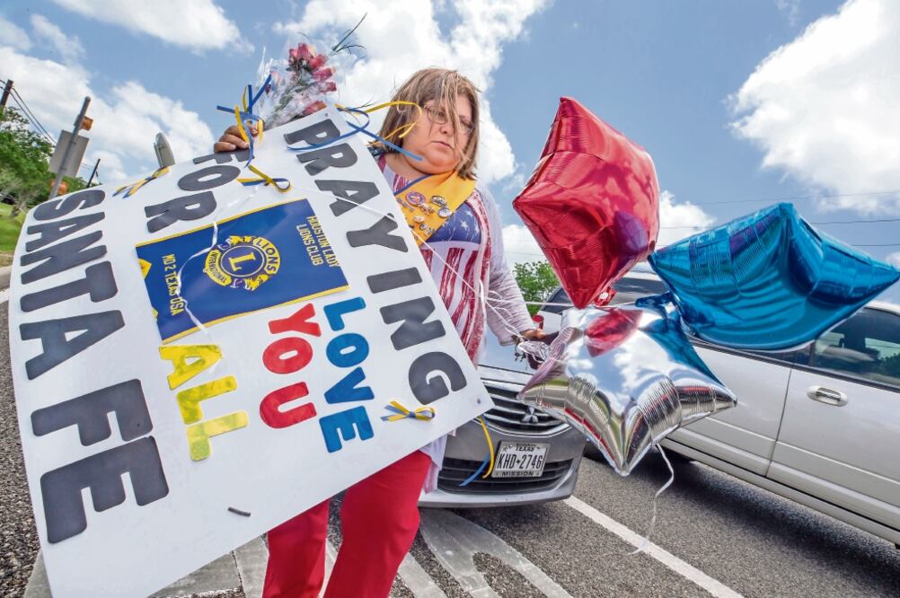 Una estadounidense carga flores y globos para colocar afuera de la secundaria Santa Fe, donde se registró el tiroteo el pasado viernes. (STUART VILLANUEVA. AP)