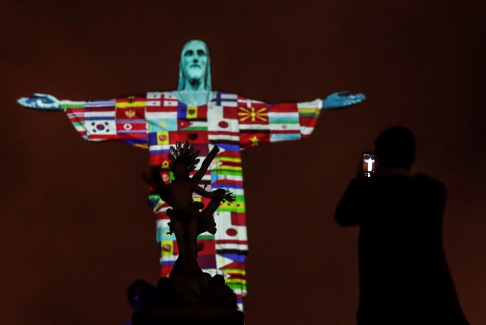 El Cristo Redentor, en Brasil, proyecto las banderas de los países afectados por el coronavirus. Foto: Antonio Lacerda. EFE
