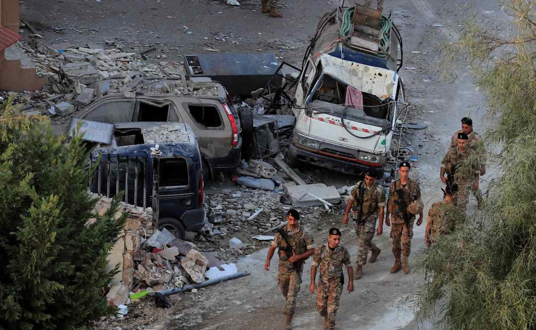 Soldados del ejército libanés caminan junto a coches destruidos en el lugar donde un ataque aéreo israelí alcanzó un edificio, en el pueblo de Barja, al sur de Beirut, Líbano, el sábado 12 de octubre de 2024. Foto AP