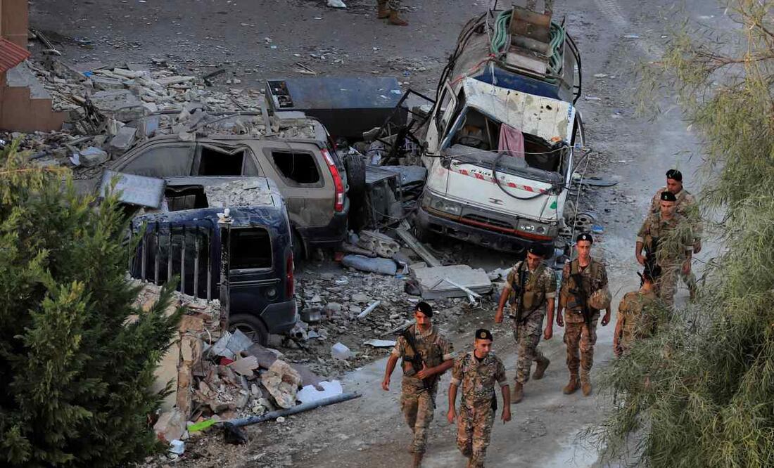 Soldados del ejército libanés caminan junto a coches destruidos en el lugar donde un ataque aéreo israelí alcanzó un edificio, en el pueblo de Barja, al sur de Beirut, Líbano, el 12 de octubre de 2024. Foto AP